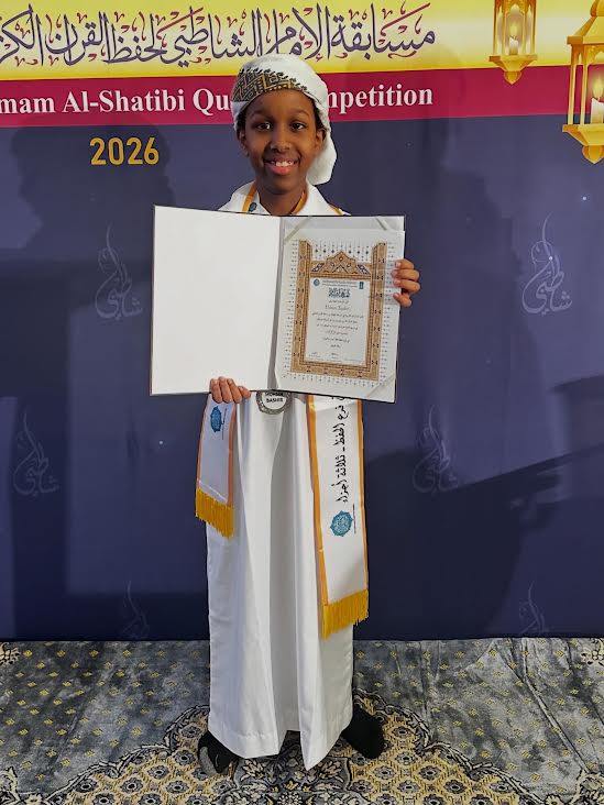 A young student holding his certificate at the 2026 Imam Al-Shatibi Qur'an Competition